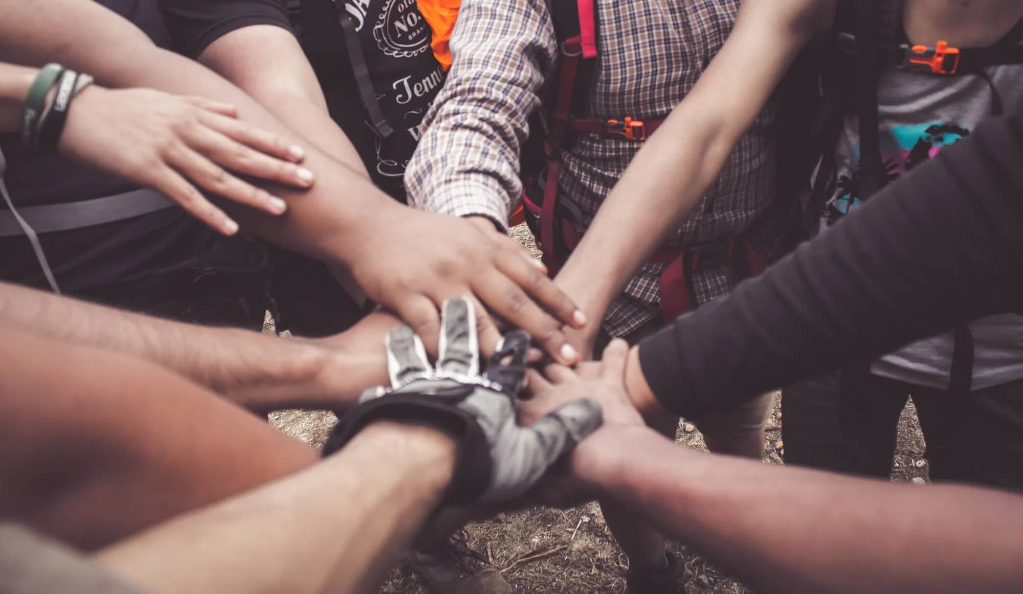 A group of people placing their hands together as a sign of teamwork